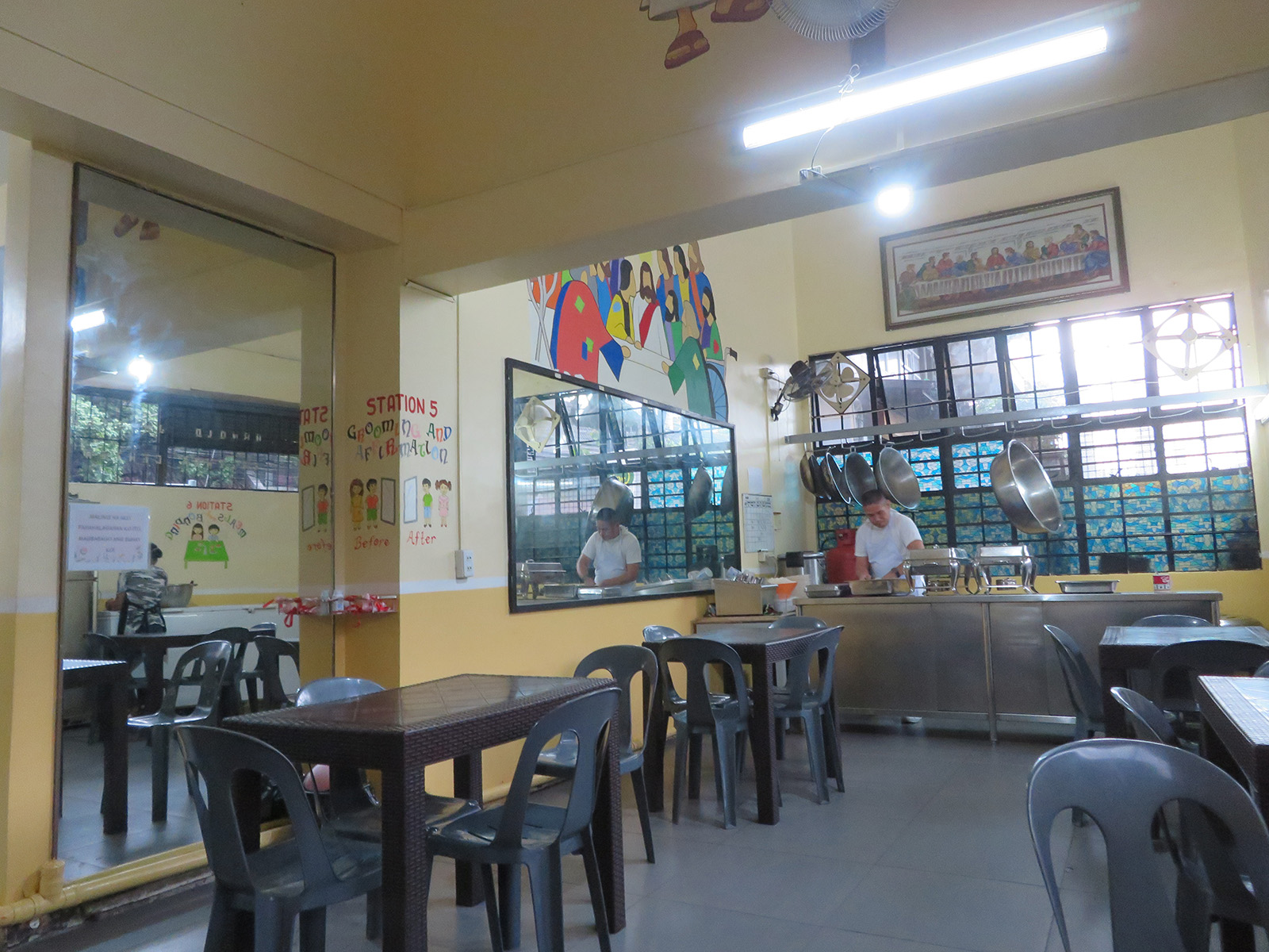 empty tables and mirrors in front of kitchen